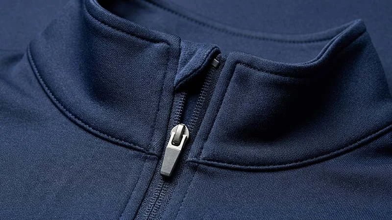 A close-up showing the details of a quarter-zip's collar, zipper garage, and chin guard.