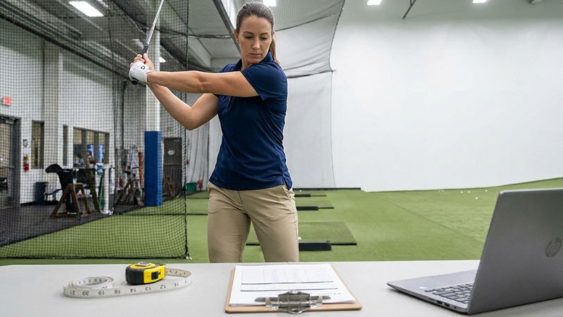 A person wearing a fit sample polo and performing a golf swing to test for range of motion.