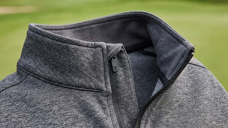 A close-up of a quarter-zip's collar and zipper garage.